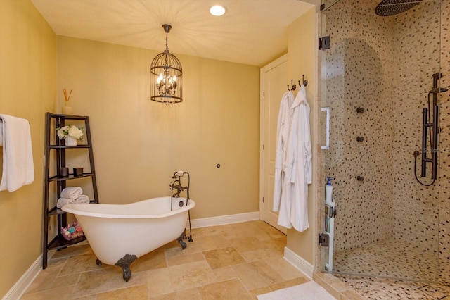 5719 Emerson Pointe Way, Orlando, FL 32819 - bathroom featuring a soaking tub, a shower stall, baseboards, and stone tile flooring
