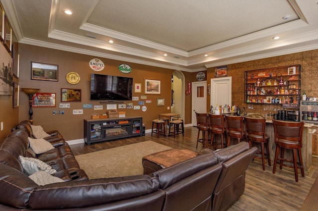 5719 Emerson Pointe Way, Orlando, FL 32819 - living area featuring a tray ceiling, arched walkways, wood finished floors, wet bar, and baseboards