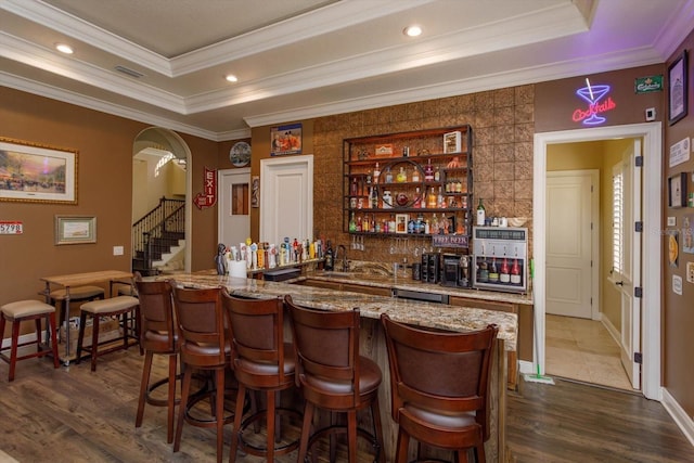 5719 Emerson Pointe Way, Orlando, FL 32819 - bar featuring arched walkways, a raised ceiling, dark wood finished floors, and wet bar