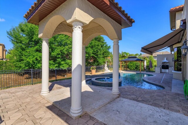 5719 Emerson Pointe Way, Orlando, FL 32819 - view of patio with a gazebo, a brick fireplace, fence, and a pool with connected hot tub