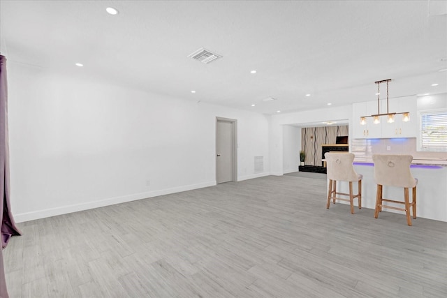 unfurnished living room with baseboards, recessed lighting, visible vents, and light wood-style floors