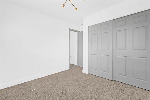 unfurnished bedroom featuring baseboards, a closet, and light colored carpet