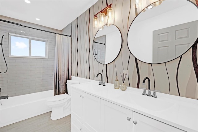 bathroom featuring toilet, wood finished floors, a sink, double vanity, and shower / bathtub combination with curtain