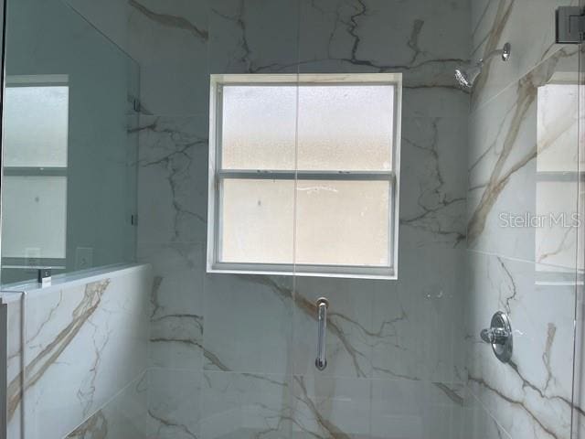 interior space featuring a marble finish shower