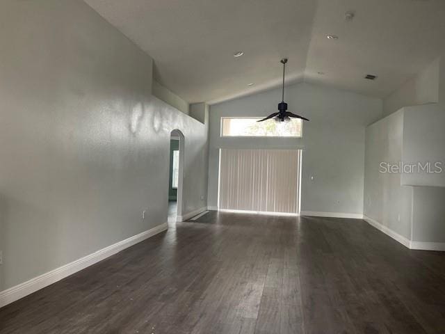 unfurnished room featuring dark wood-style floors, arched walkways, ceiling fan, and baseboards