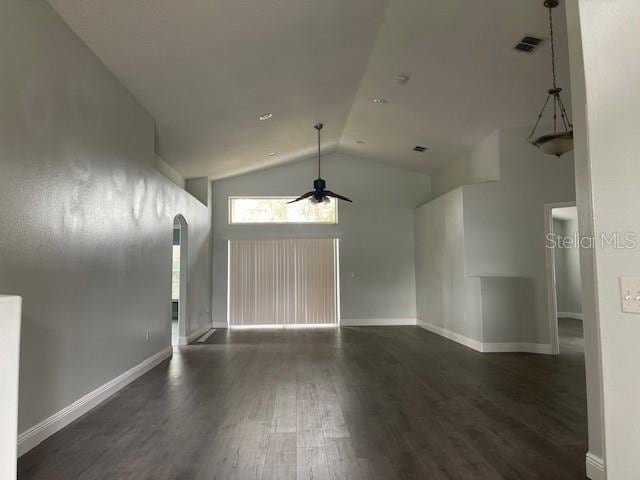 interior space featuring arched walkways, ceiling fan, visible vents, baseboards, and dark wood-style floors