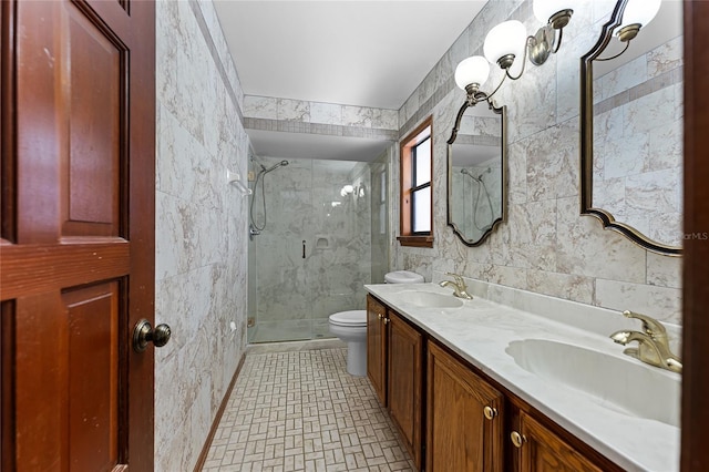 full bath featuring toilet, a stall shower, tile walls, and a sink