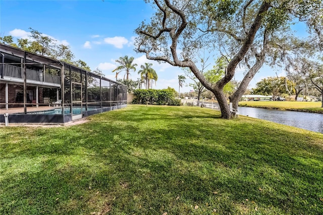 view of yard with glass enclosure, a water view, and an outdoor pool