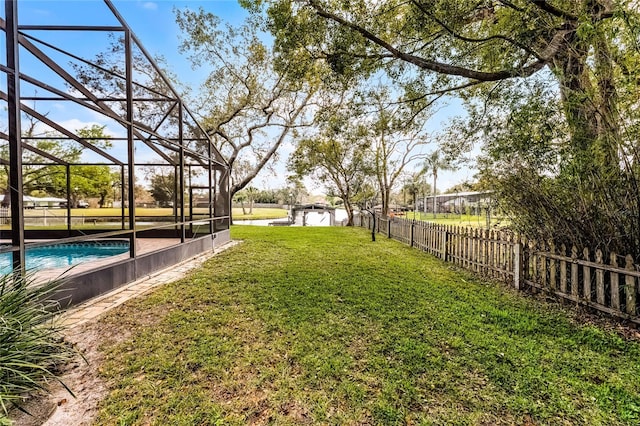 view of yard with glass enclosure, a fenced backyard, and a fenced in pool