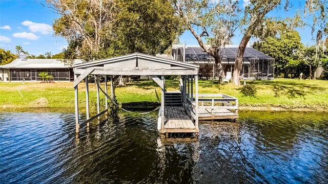 dock area featuring a water view, boat lift, and a yard