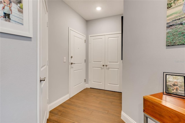 hallway with light wood-style flooring and baseboards