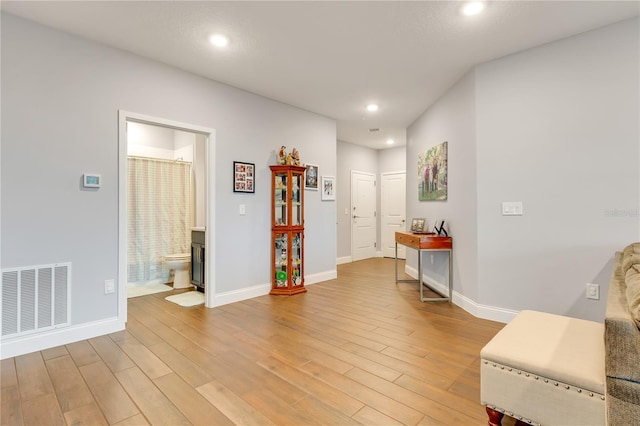 interior space with light wood-type flooring, visible vents, and baseboards