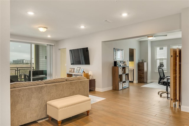 living room with light wood finished floors, recessed lighting, a ceiling fan, and baseboards