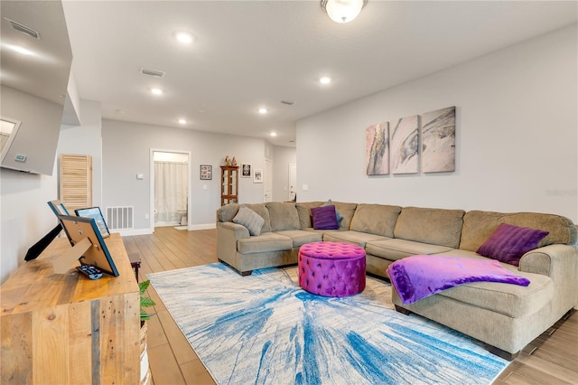 living room featuring recessed lighting, visible vents, baseboards, and wood finished floors