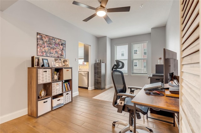 office with light wood finished floors, ceiling fan, and baseboards