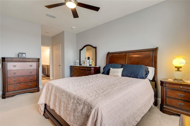 bedroom with a ceiling fan, visible vents, light carpet, and ensuite bathroom