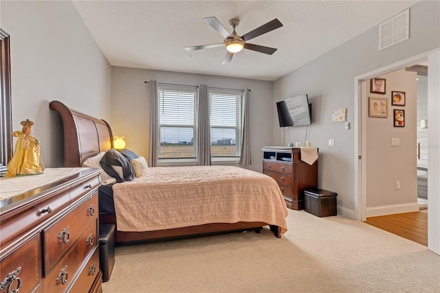 bedroom with light carpet, baseboards, visible vents, and a ceiling fan