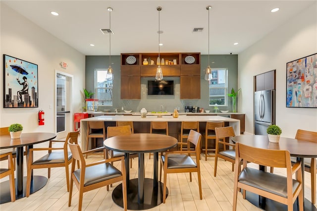 kitchen featuring light countertops, freestanding refrigerator, visible vents, and modern cabinets