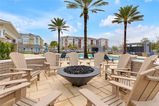 view of patio with a residential view, a fire pit, and a community pool