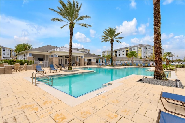 pool with a residential view, a patio area, and fence