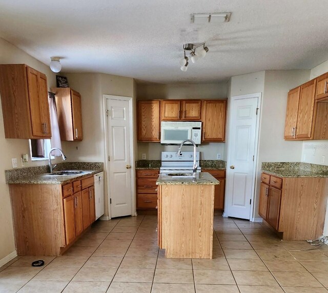2143 Tealwood Cir, Tavares, FL 32778 - kitchen with white appliances, brown cabinets, a kitchen island, and a sink
