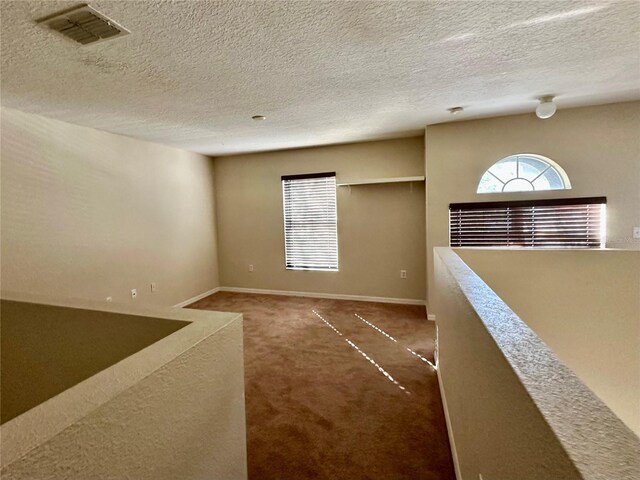 2143 Tealwood Cir, Tavares, FL 32778 - empty room featuring dark carpet, visible vents, plenty of natural light, and baseboards