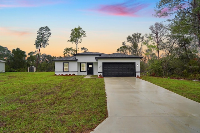 view of front facade with a front yard, driveway, an attached garage, and stucco siding