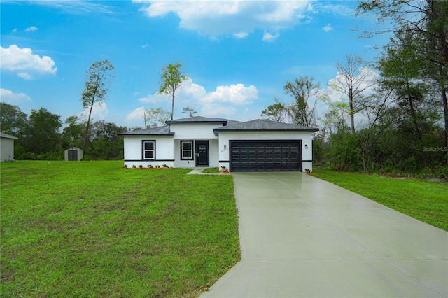 prairie-style house featuring concrete driveway, an attached garage, a front lawn, and stucco siding