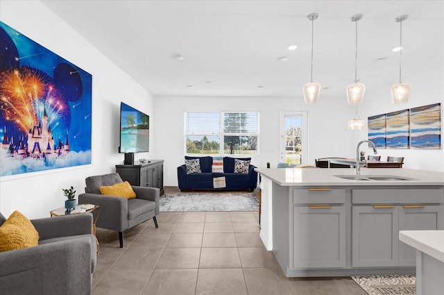 kitchen with open floor plan, light countertops, light tile patterned floors, and a sink