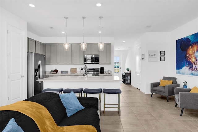 kitchen featuring recessed lighting, appliances with stainless steel finishes, light countertops, and gray cabinetry