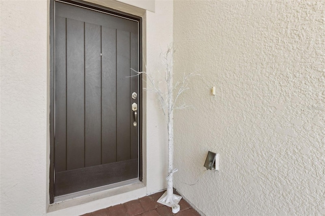 entrance to property featuring stucco siding