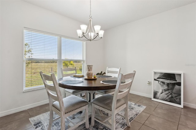 dining space featuring light tile patterned floors, baseboards, and an inviting chandelier