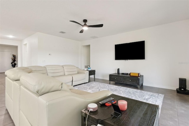 living room with tile patterned flooring, visible vents, ceiling fan, and baseboards