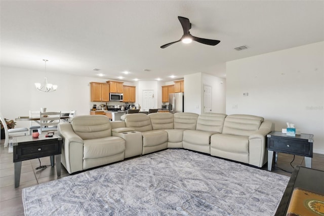 living area with light tile patterned floors, recessed lighting, visible vents, and ceiling fan with notable chandelier