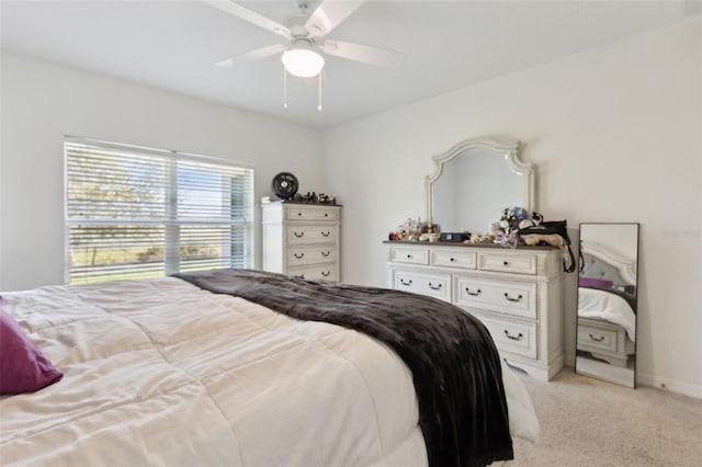 bedroom with a ceiling fan, light carpet, and baseboards