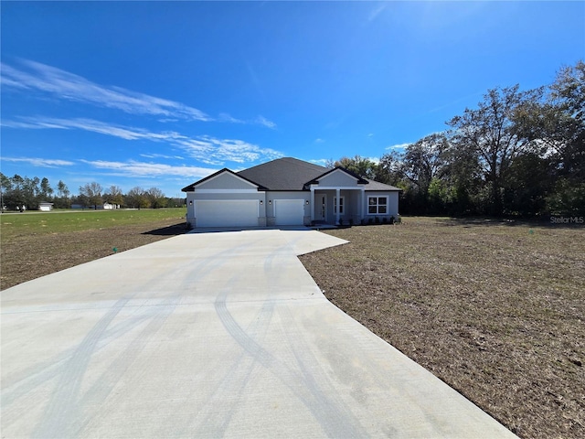 ranch-style house with a garage, concrete driveway, and a front lawn