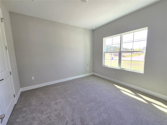 carpeted spare room with baseboards