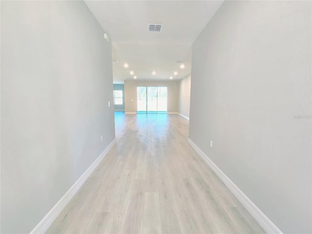 corridor featuring recessed lighting, visible vents, light wood finished floors, and baseboards