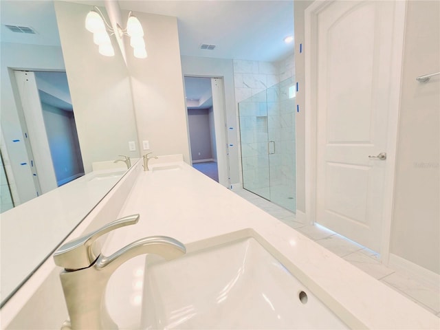 full bath with visible vents, a sink, a shower stall, and double vanity