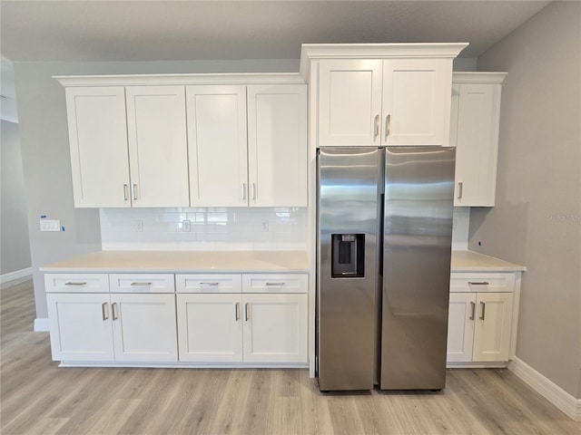 kitchen with white cabinets, tasteful backsplash, and stainless steel refrigerator with ice dispenser