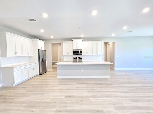 kitchen with stainless steel appliances, light countertops, visible vents, and recessed lighting