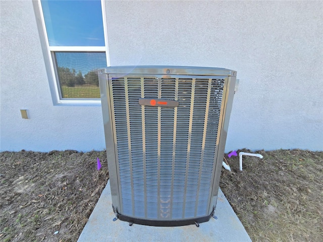 exterior details featuring central AC unit and stucco siding