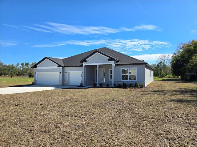 view of front of property featuring concrete driveway, a front lawn, an attached garage, and stucco siding