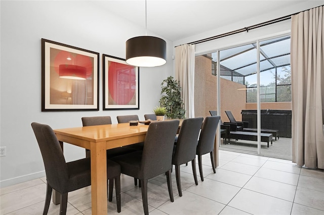 dining room featuring light tile patterned floors, baseboards, and vaulted ceiling