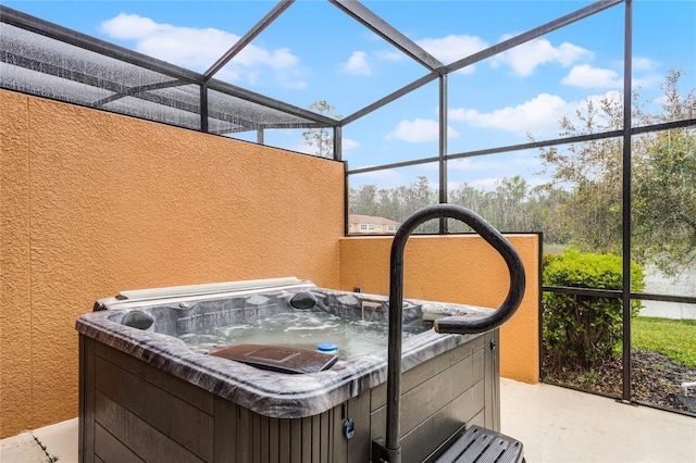 view of patio / terrace featuring a lanai and a hot tub