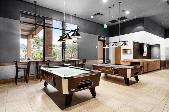 recreation room featuring light tile patterned floors, a towering ceiling, billiards, and visible vents