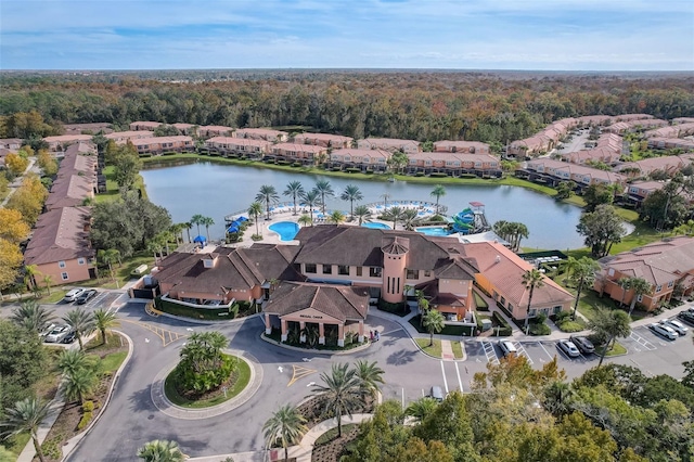 birds eye view of property featuring a water view and a view of trees