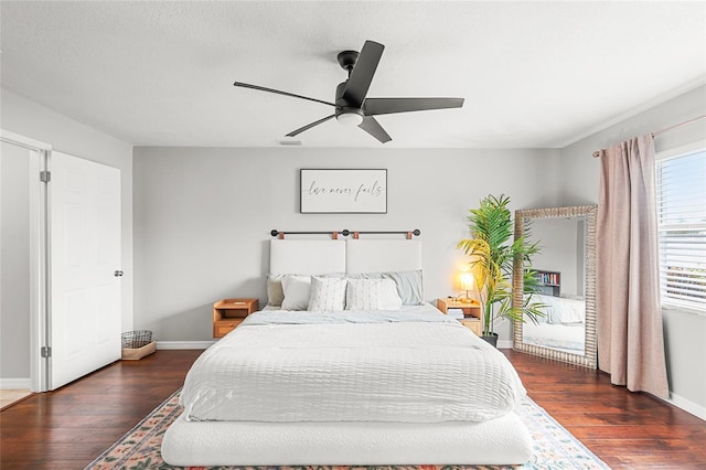 bedroom with baseboards, visible vents, and wood finished floors