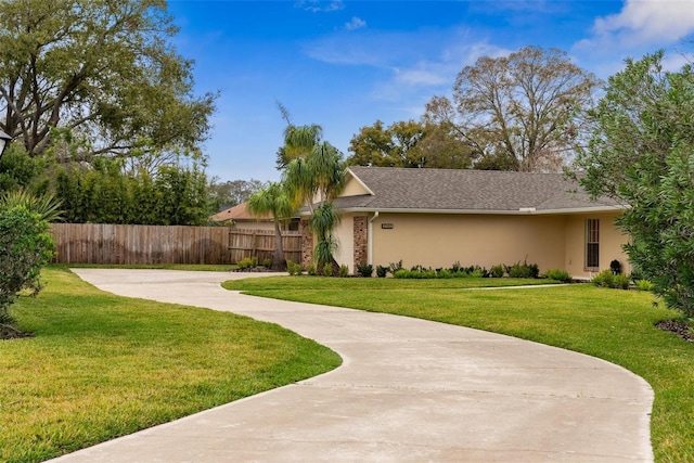 view of property exterior with a yard, fence, and stucco siding