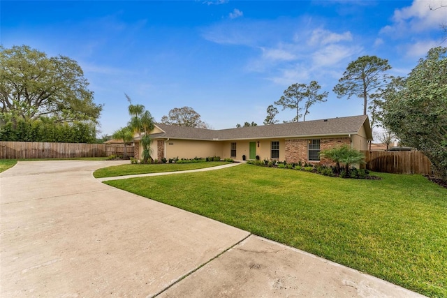 ranch-style home with brick siding, driveway, a front lawn, and fence